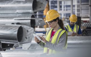 Female supervisor using digital tablet in steel factory