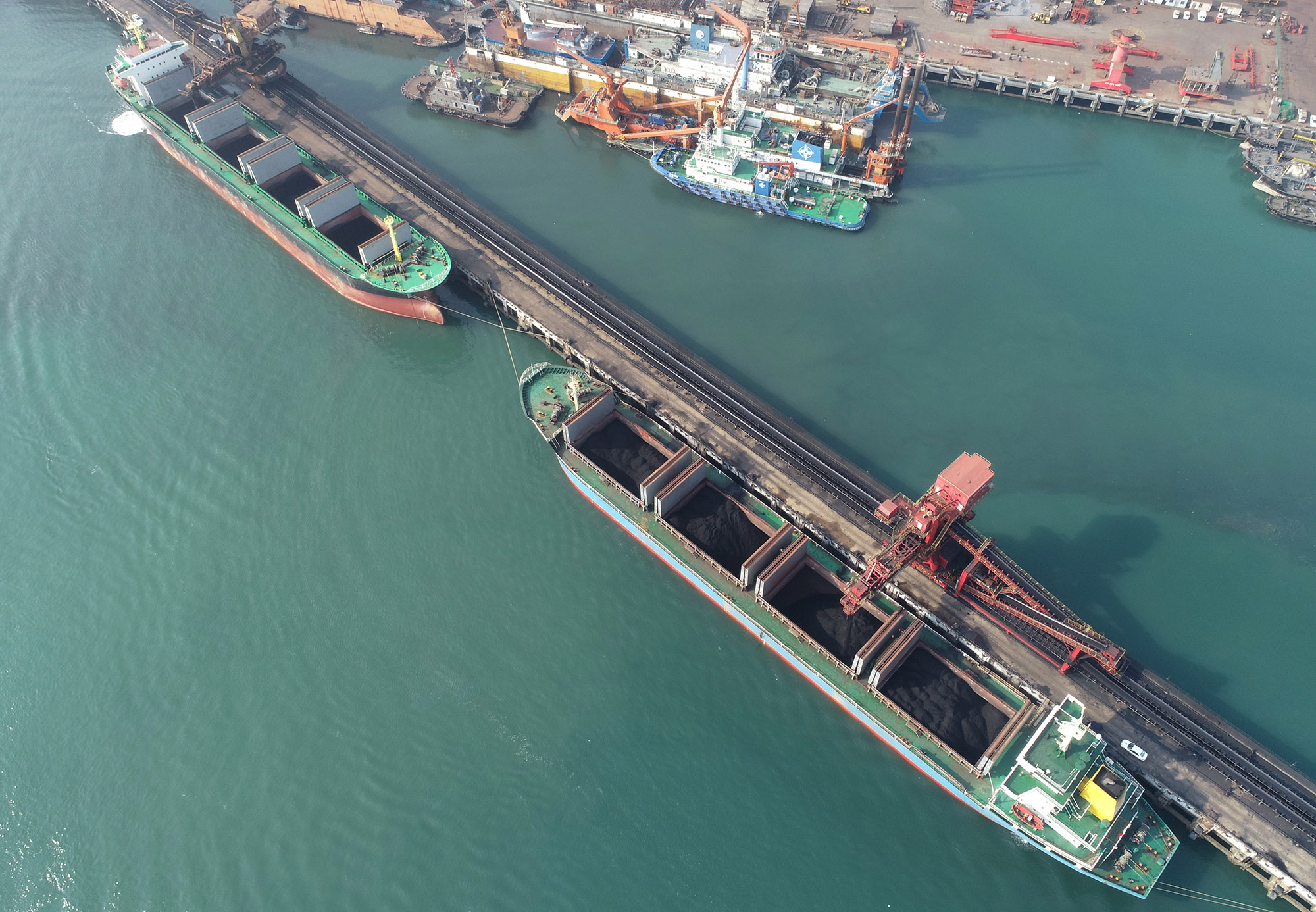 Aerial view of coal being loaded onto a ship in port