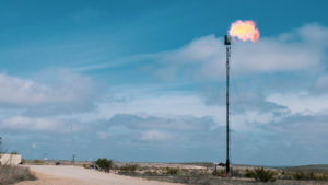 Landscape with vertical gas pipeline 'flaring' methane