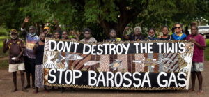 Tiwi Islanders holding their protest banner: Don't destroy the Tiwi's, stop Barossa gas"