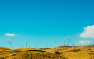 Wind farm on hill against blue sky
